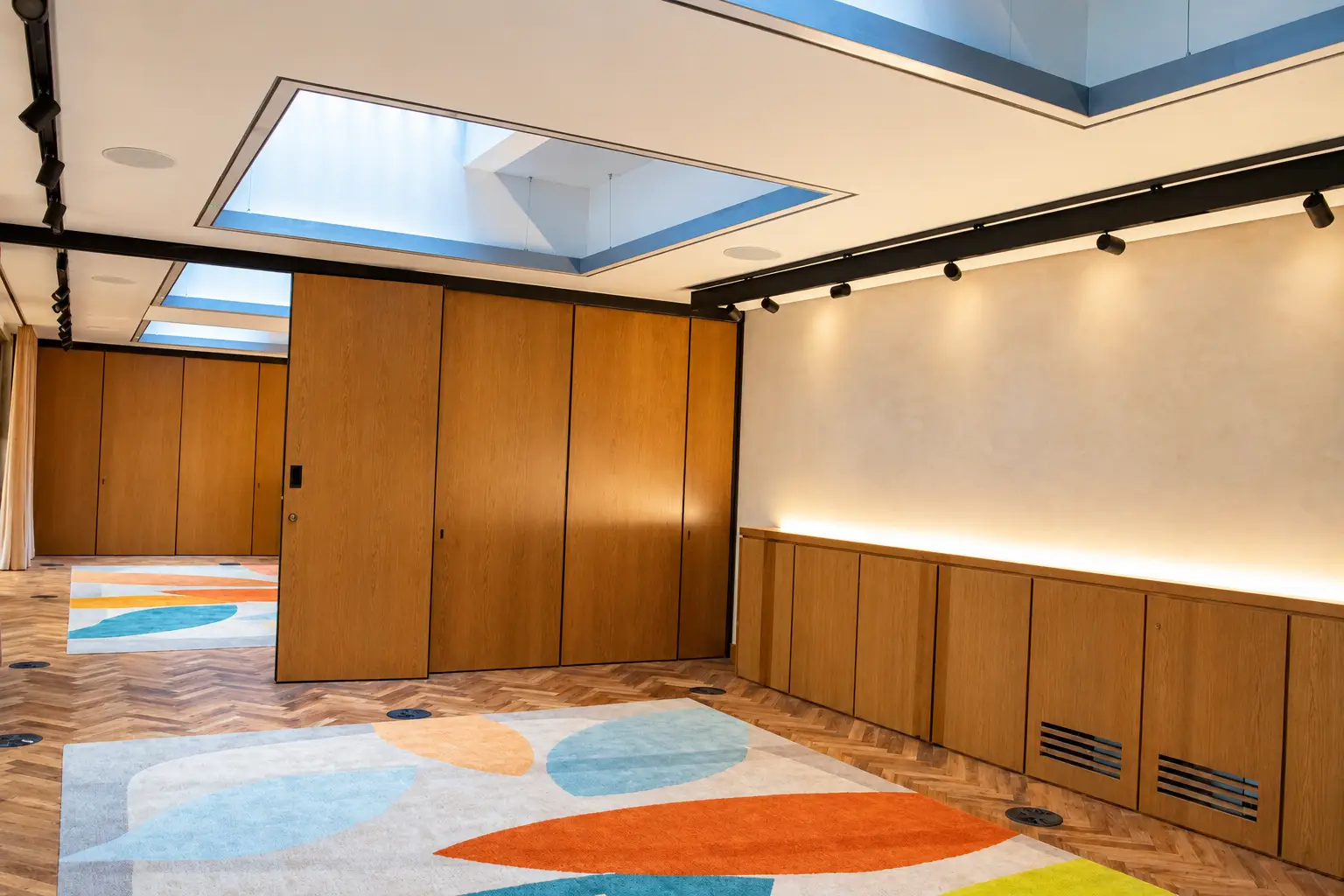 Skylit Oak Corridor with Geometric Rugs-3